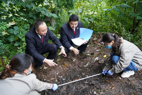 文化遗产检察官游强(左二)、龙云(右二)在盗掘古墓葬现场勘验