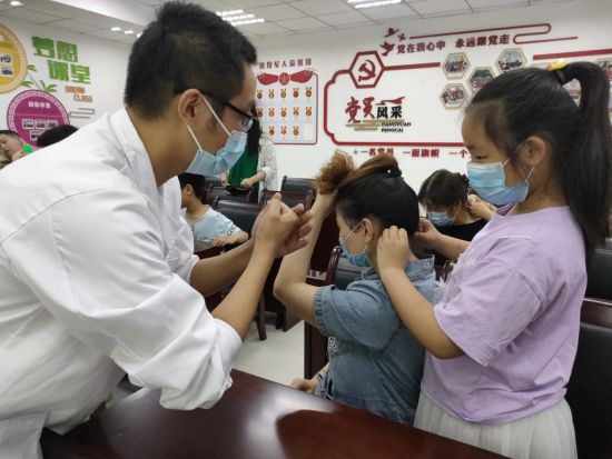 图为推拿师指导青少年为家长按摩。共青团江北区委供图 图为推拿师指导青少年为家长按摩。共青团江北区委供图