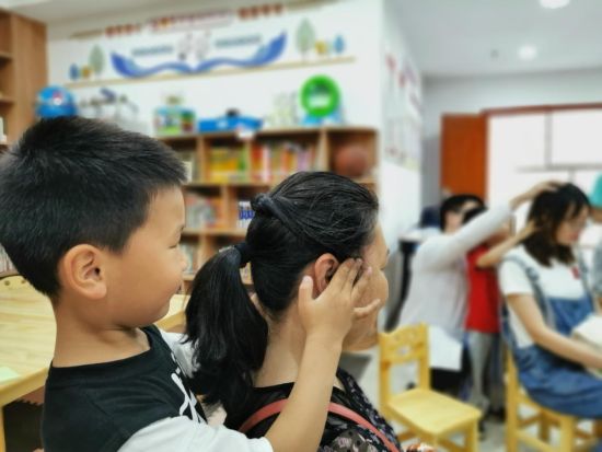 图为青少年为家长按摩。共青团江北区委供图 图为青少年为家长按摩。共青团江北区委供图