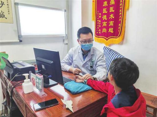 图为杨通江为患者把脉。秀山县人民医院供图 图为杨通江为患者把脉。秀山县人民医院供图