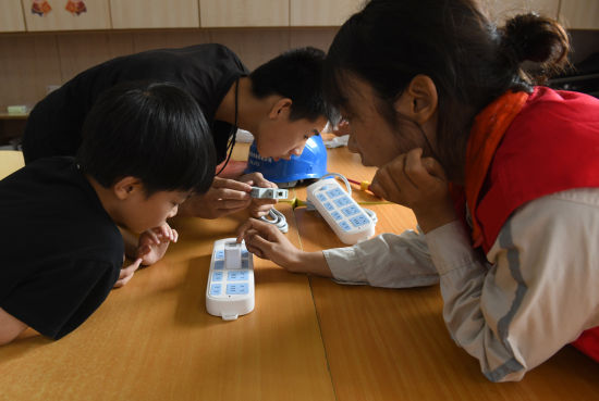 图为视力障碍的学生触摸插座学习安全用电知识。周毅 摄 图为视力障碍的学生触摸插座学习安全用电知识。周毅 摄
