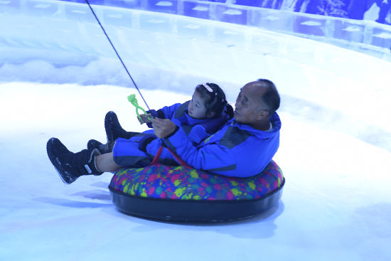 图为市民带着小孩在冰雪乐园玩耍。周毅 摄