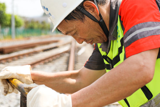 唐家沱基地,工务检修车间员工谭顺全正在进行线路扣件松动及复紧作业。 王筱筠 摄 唐家沱基地,工务检修车间员工谭顺全正在进行线路扣件松动及复紧作业。 王筱筠 摄