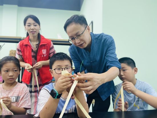 图为杨乾波指导小朋友们综编。 图为杨乾波指导小朋友们综编。