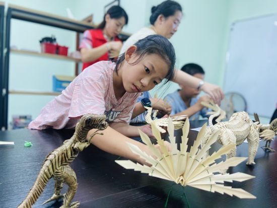 图为留守儿童现场体验感受棕编。 图为留守儿童现场体验感受棕编。