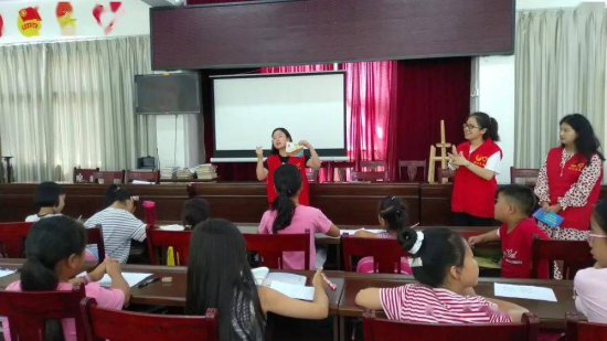 图为志愿者为留守儿童“讲课”。 黔江区委统战部供图