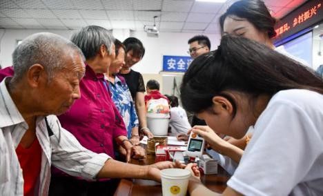 图为重庆医科大学护理学院学生为村民测血糖。吴佳欣 摄 图为重庆医科大学护理学院学生为村民测血糖。吴佳欣 摄
