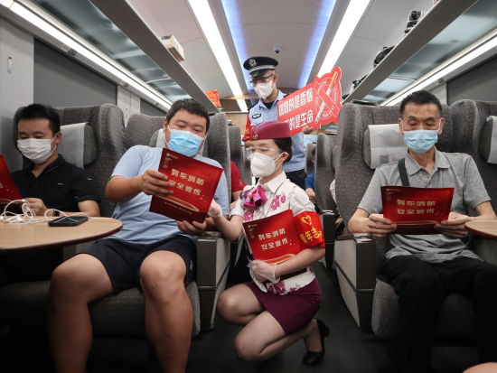图为民警和乘务员对旅客展开宣传。中国铁路成都局集团有限公司供图 图为民警和乘务员对旅客展开宣传。中国铁路成都局集团有限公司供图