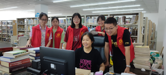图为志愿者们在图书馆采编室认真学习业务技能。黔江区委统战部供图