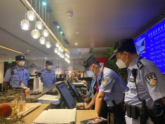 图为民警在宾馆前台详细检查住宿登记情况。 受访者供图 图为民警在宾馆前台详细检查住宿登记情况。 受访者供图