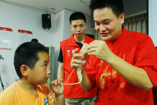 图为青少年与民间艺人向洪老师共同制作糖人。 图为青少年与民间艺人向洪老师共同制作糖人。