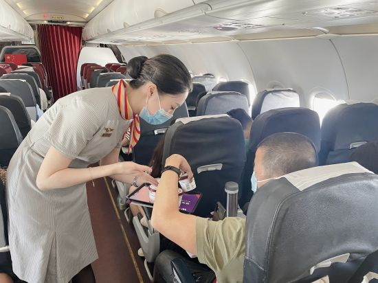 图为西部航空乘务员为旅客推荐冰淇淋。周朕 摄 图为西部航空乘务员为旅客推荐冰淇淋。周朕 摄