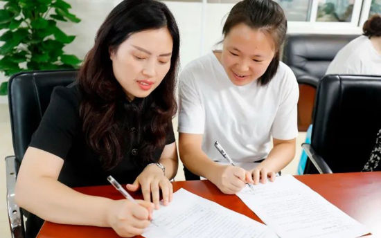 图为师徒在责任书上签名。刘万娟 摄 图为师徒在责任书上签名。刘万娟 摄