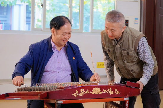 李浦弘帮艺术团成员校准琴弦。彭心怡 摄 李浦弘帮艺术团成员校准琴弦。彭心怡 摄