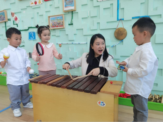图为湛美霞和孩子们一起演奏乐器。 杨梦逸 摄 图为湛美霞和孩子们一起演奏乐器。 杨梦逸 摄