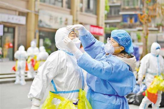 11月14日,九龙坡区杨家坪街道兴胜路社区,志愿者陈晓宇(右)正在帮助医护人员穿防护服。记者 郑宇 通讯员 孙小刚 摄/视觉重庆 11月14日,九龙坡区杨家坪街道兴胜路社区,志愿者陈晓宇(右)正在帮助医护人员穿防护服。记者 郑宇 通讯员 孙小刚 摄/视觉重庆