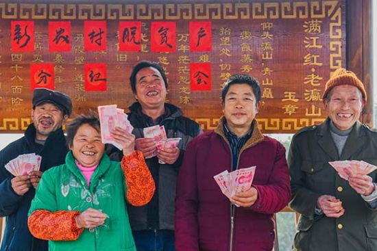 綦江区石角镇新农村村委会广场,村民展示自己的领到的分红款。陈星宇 摄 綦江区石角镇新农村村委会广场,村民展示自己的领到的分红款。陈星宇 摄