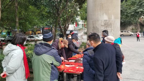 图为志愿者现场为社区居民书写春联。彭群英 摄 图为志愿者现场为社区居民书写春联。彭群英 摄