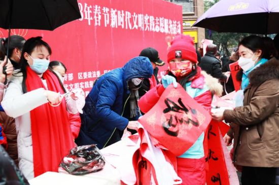 志愿者在永川区红旗广场向市民赠送春联。 刘洪兵 摄