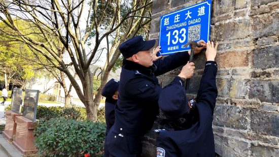民警安装二维码门楼牌。 田维祎 摄 民警安装二维码门楼牌。 田维祎 摄