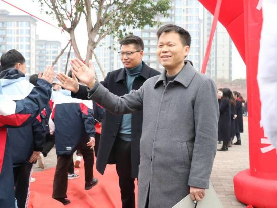 图为永川凤凰湖中学校长刘远平迎接学生。永川凤凰湖中学校供图 图为永川凤凰湖中学校长刘远平迎接学生。永川凤凰湖中学校供图