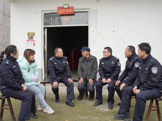 图为民警、村委会工作人员与谭大爷一起围坐交流。 垫江监狱供图 图为民警、村委会工作人员与谭大爷一起围坐交流。 垫江监狱供图