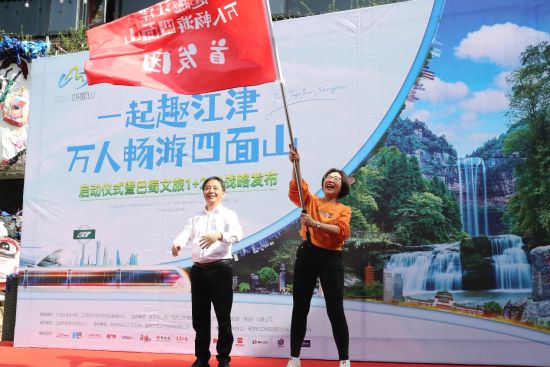 图为江津区四面山管理委员会副主任廖章言向游客代表授旗。 主办方 供图 图为江津区四面山管理委员会副主任廖章言向游客代表授旗。 主办方 供图