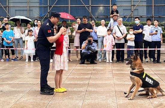 图为一位小朋友正在训犬员的指导下,向警犬发出指令。张旭 摄 图为一位小朋友正在训犬员的指导下,向警犬发出指令。张旭 摄
