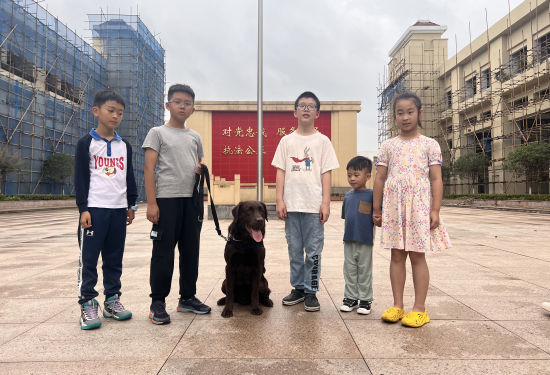 图为小朋友们与警犬“哎咪”合影留念。张旭 摄 图为小朋友们与警犬“哎咪”合影留念。张旭 摄