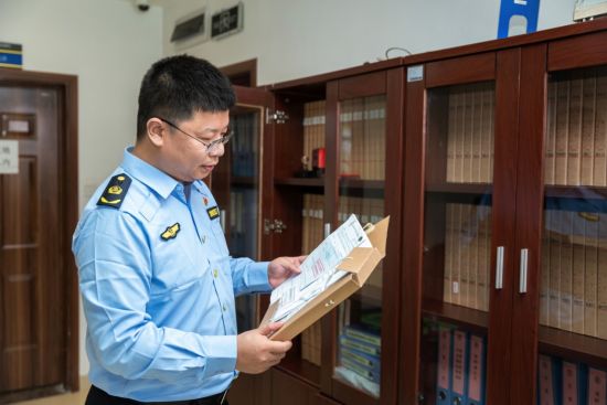 图为冯重阳一丝不苟地查阅交通运输企业安全档案。 受访者供图 图为冯重阳一丝不苟地查阅交通运输企业安全档案。 受访者供图