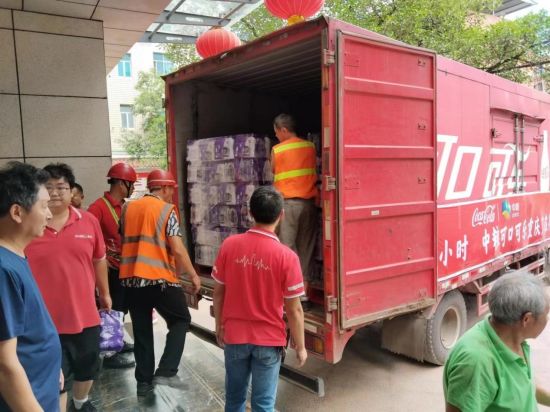 图为志愿者搬运瓶装饮用水。中粮可口可乐重庆厂供图 图为志愿者搬运瓶装饮用水。中粮可口可乐重庆厂供图