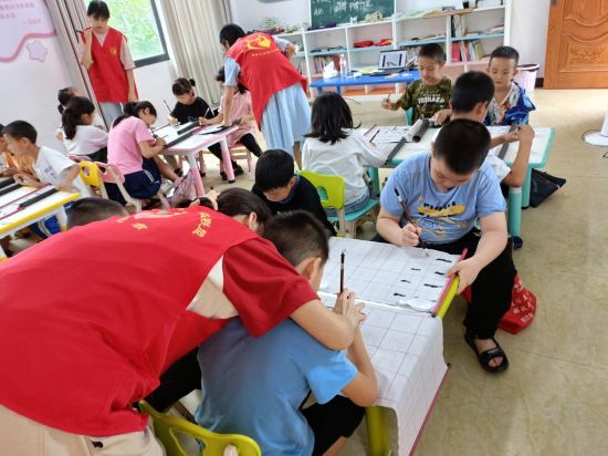 图为民革党员志愿者教孩子们书法。 黔江区委统战部 供图 图为民革党员志愿者教孩子们书法。 黔江区委统战部 供图