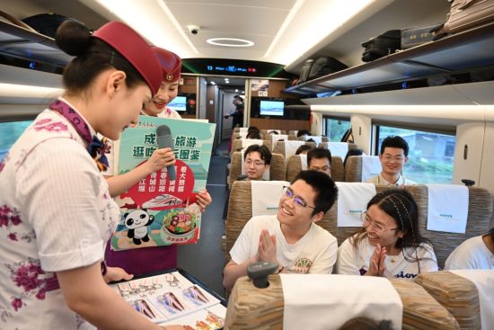 7月26日,在G8612次成渝智能复兴号列车上,乘务员正在为参与活动的旅客发放礼品。通讯员 钟洁 摄 7月26日,在G8612次成渝智能复兴号列车上,乘务员正在为参与活动的旅客发放礼品。通讯员 钟洁 摄