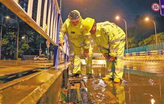7月27日凌晨,沙坪坝区一城市道路上,市政工人正抓紧疏通因暴雨形成的道路积水,保障道路安全。通讯员 郭晋 摄/视觉重庆 7月27日凌晨,沙坪坝区一城市道路上,市政工人正抓紧疏通因暴雨形成的道路积水,保障道路安全。通讯员 郭晋 摄/视觉重庆