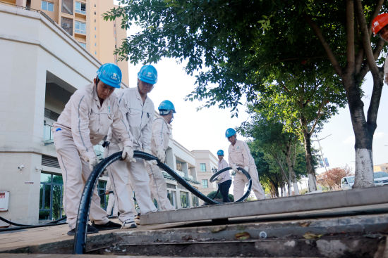 图为国网重庆永川供电公司员工与国网重庆大足供电公司员工一起敷设电缆。王非凡 摄 图为国网重庆永川供电公司员工与国网重庆大足供电公司员工一起敷设电缆。王非凡 摄