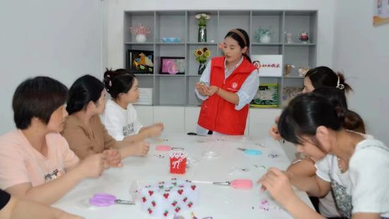 图为“龙乡巧姐”王雪指导妇女们做手工串珠。 铜梁区委宣传部供图 图为“龙乡巧姐”王雪指导妇女们做手工串珠。 铜梁区委宣传部供图