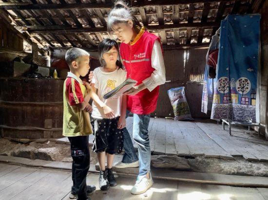 志愿者们陪着孩子们一起看书、画画。 胡娇 摄 志愿者们陪着孩子们一起看书、画画。 胡娇 摄