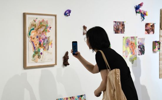 图为展出的作品吸引参观者拍照留念。 周毅 摄 图为展出的作品吸引参观者拍照留念。 周毅 摄