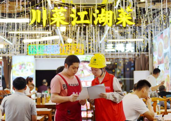 图为国网重庆市区供电公司员工在洪崖洞景区向商户宣传安全用电知识。韩薇 摄 图为国网重庆市区供电公司员工在洪崖洞景区向商户宣传安全用电知识。韩薇 摄