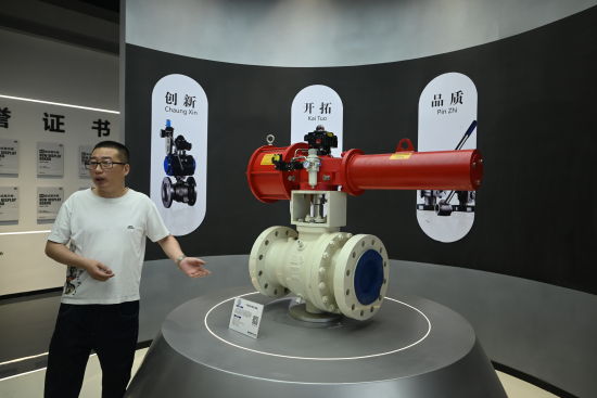图为工作人员向记者介绍阀门模型。张旭 摄 图为工作人员向记者介绍阀门模型。张旭 摄