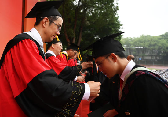 图为老师为毕业生拨穗。周毅 摄 图为老师为毕业生拨穗。周毅 摄