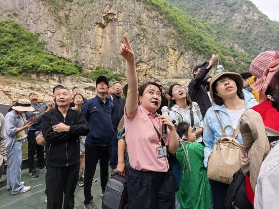 图为导游为游客介绍悬棺位置。巫山县委宣传部供图 图为导游为游客介绍悬棺位置。巫山县委宣传部供图