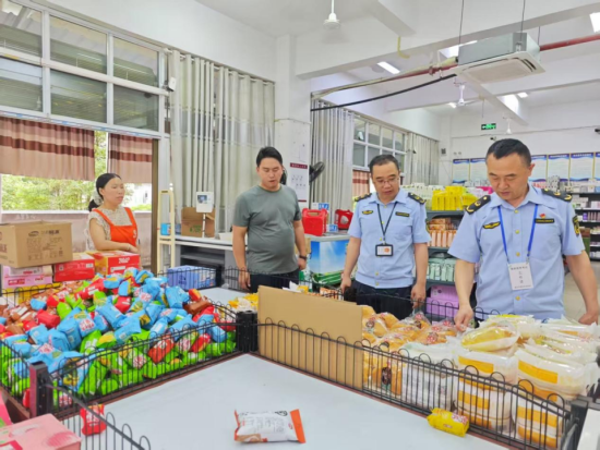 图为酉阳市场监管局工作人员对食品超市开展监督检查。尧琴 摄