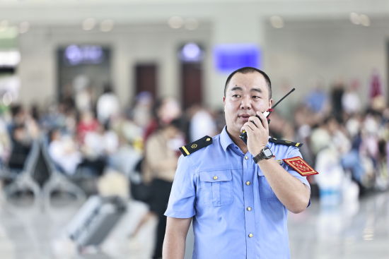 图为李亮在候车大厅巡视。易娟 摄 图为李亮在候车大厅巡视。易娟 摄