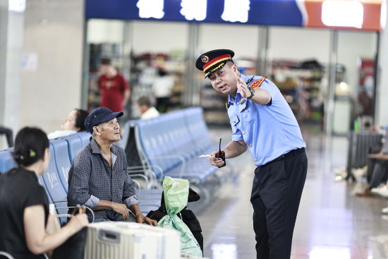 图为李亮在候车大厅为旅客提供服务。易娟 摄 图为李亮在候车大厅为旅客提供服务。易娟 摄