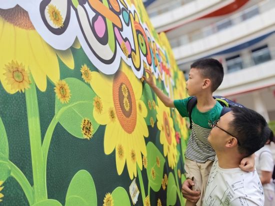 图为北碚区两江春晖小学一年级新生在“葵花墙”上贴上小心愿。周辉 摄 图为北碚区两江春晖小学一年级新生在“葵花墙”上贴上小心愿。周辉 摄