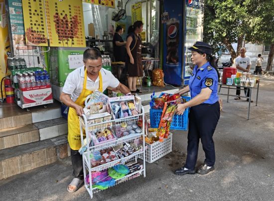图为城管执法人员帮助摊贩规范经营。 巴南区城管局供图 图为城管执法人员帮助摊贩规范经营。 巴南区城管局供图