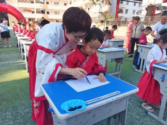 图为新生在老师的指导下书写“人”字。合川区云门小学 供图 图为新生在老师的指导下书写“人”字。合川区云门小学 供图