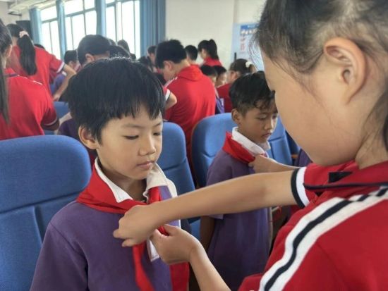 图为高年级队员为新入队队员系上红领巾。合川区龙市小学 供图 图为高年级队员为新入队队员系上红领巾。合川区龙市小学 供图