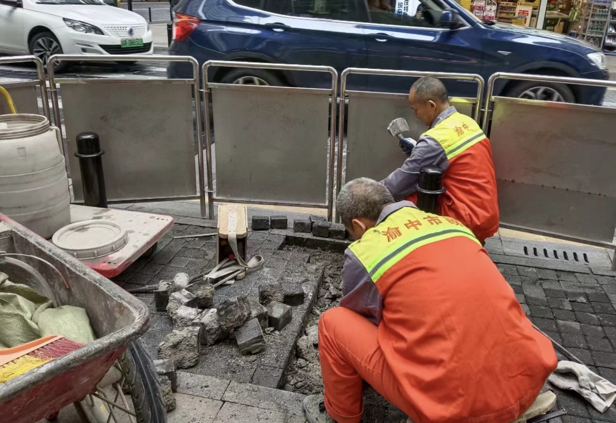 图为工作人员对路面进行维修。解放碑城市综合管理所供图 图为工作人员对路面进行维修。解放碑城市综合管理所供图